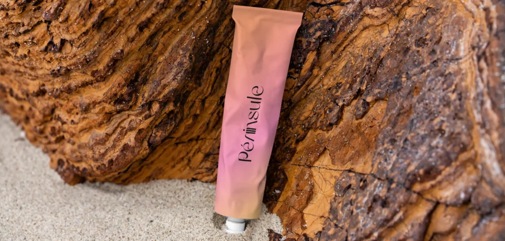 Packaging crème sur la plage avec le logo Péninsule